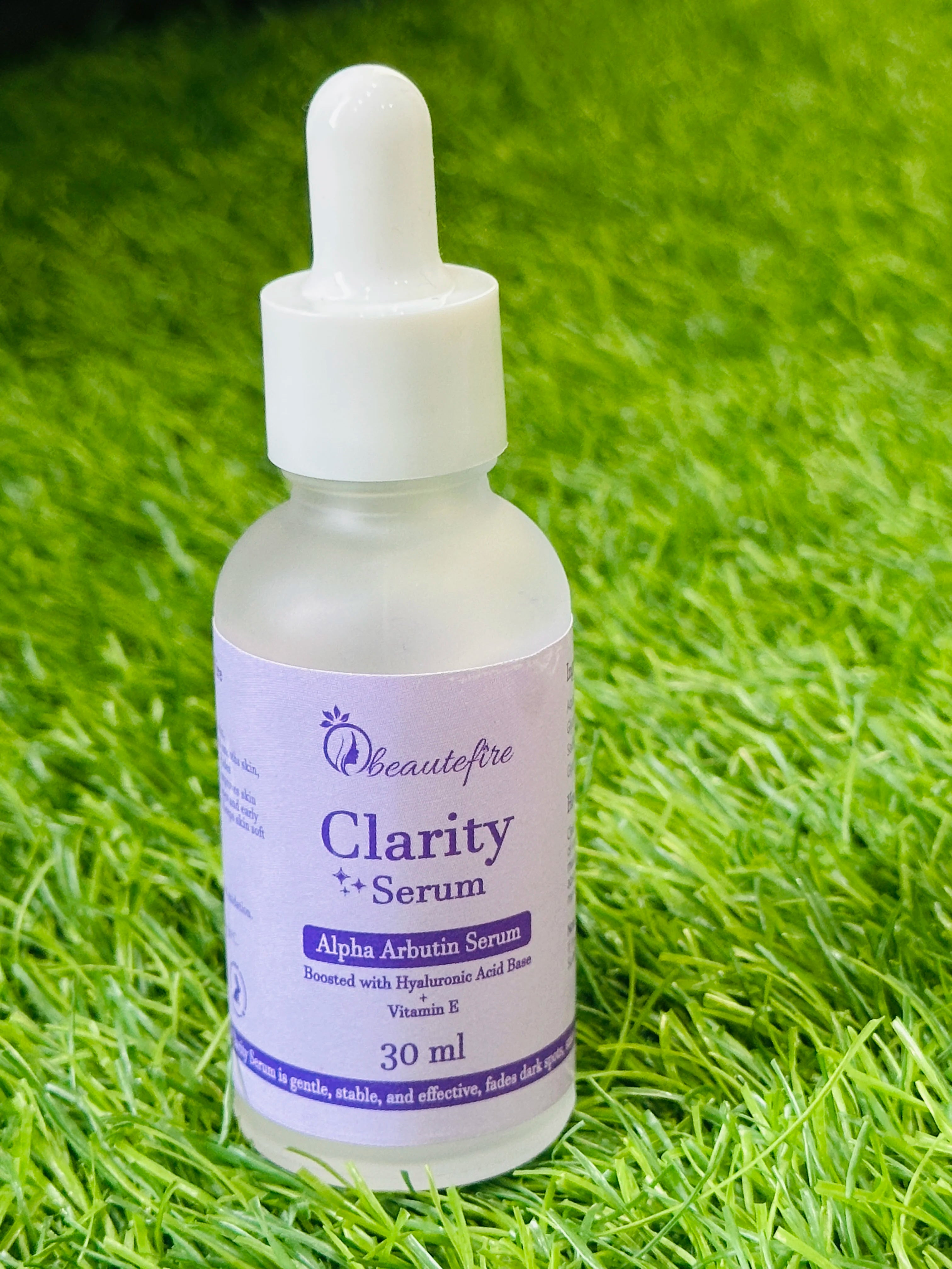 Beautefire Clarity Serum outdoors on grass ā natural brightening skincare shot highlighting purity and hydration.