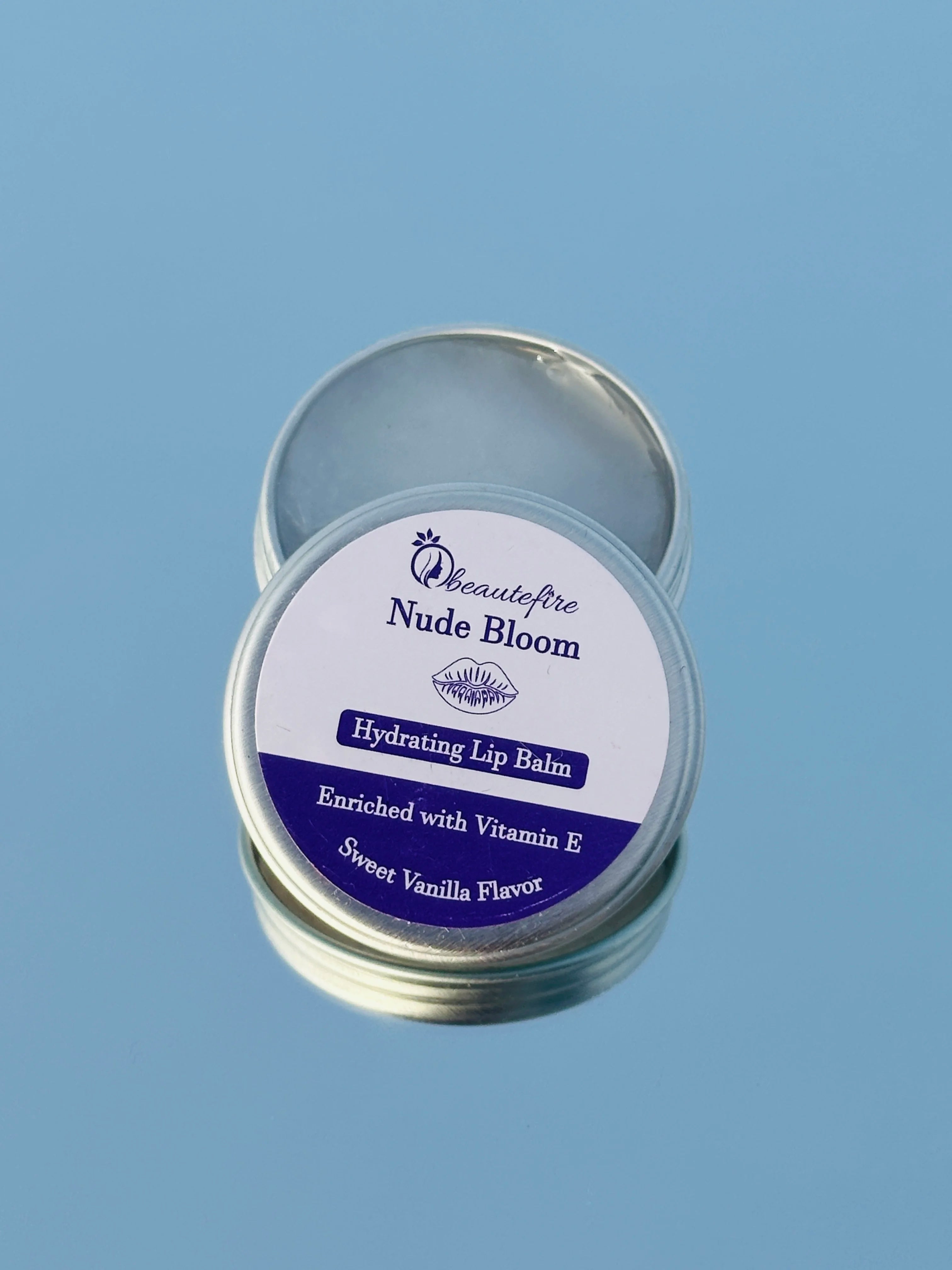 Beautefire Nude Bloom Lip Balm on mirror ā elegant nude-tinted balm reflecting a soft, natural glow with deep nourishment.