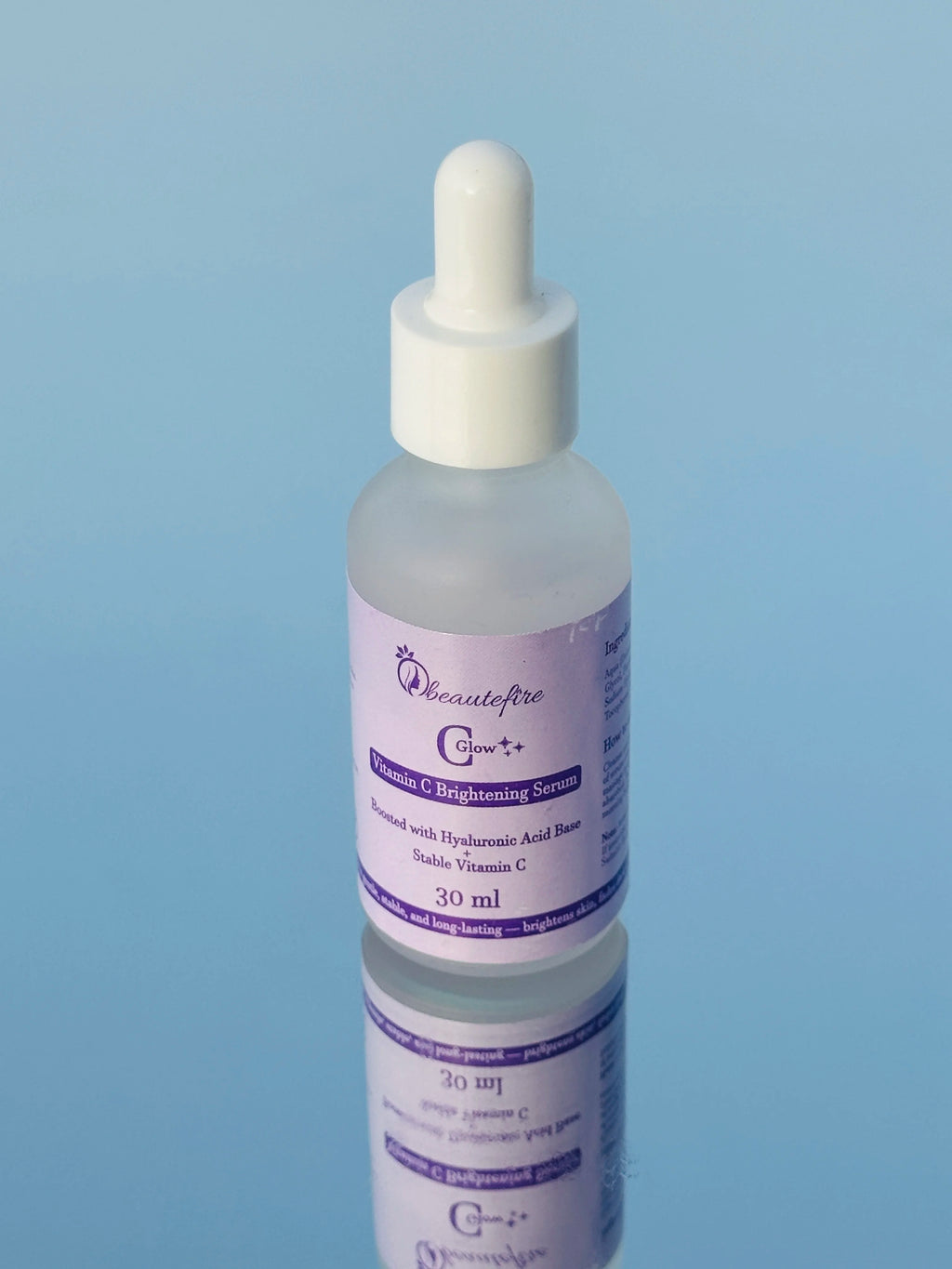 Beautefire C Glow Serum placed on light blue mirror — natural light capture of hydrating, glow-boosting Vitamin C serum.