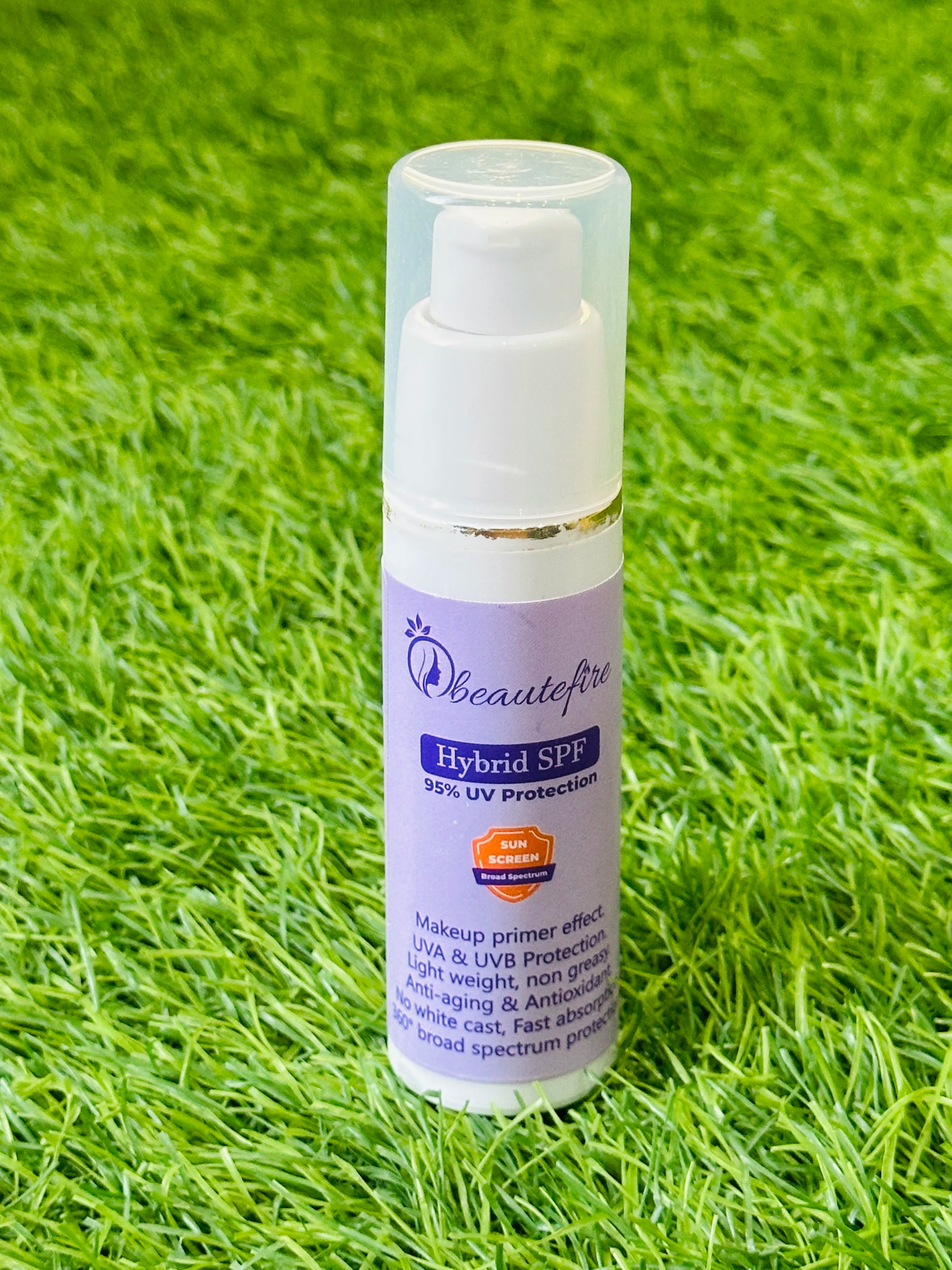 Beautefire Hybrid SPF bottle on grass — natural sunlight shot showing elegant, daily UV protection formula.