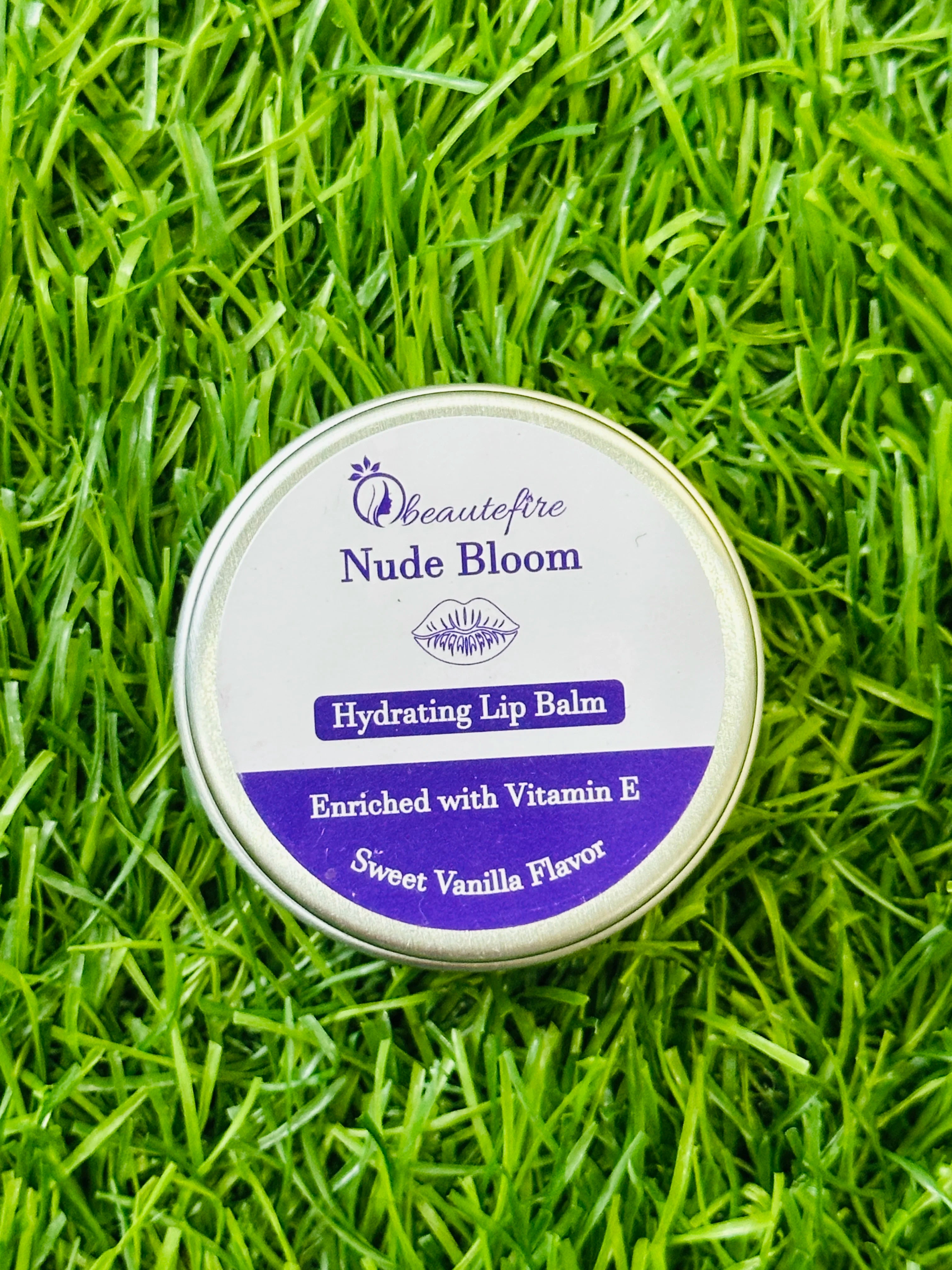Beautefire Nude Bloom Lip Balm on grass — natural daylight shot highlighting nourishing, non-sticky lip care for daily use.