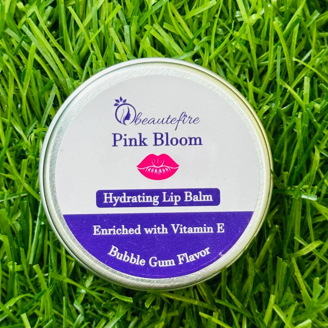 Beautefire Pink Bloom Lip Balm on grass — natural beauty flat lay showing soft tint and nourishing formula.